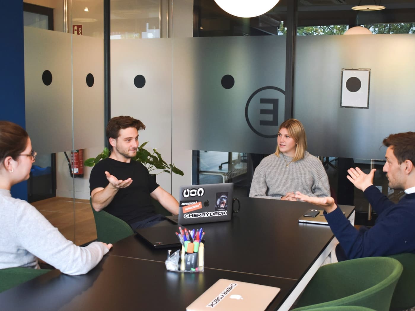 A small startup team talking through ideas around a meeting table